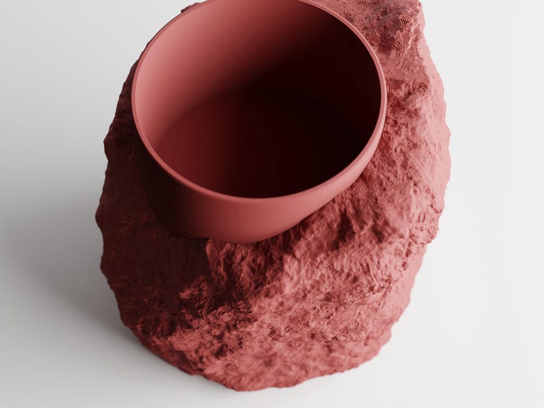 Eine halbverpackte 3D-gedruckte Vase mit Steinstruktur und moderner Ästhetik